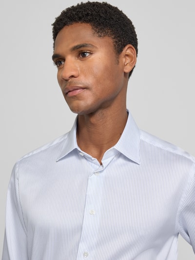 Männermodel trägt Regular Fit Business-Hemd mit extra langem Arm von Christian Berg Men, feines Streifenmuster, Reine Baumwolle, Nahaufnahme Oberkörper. Rückenlänge bei Größe 39/40: 83 cm, Schulterbreite: 47 cm, Ärmellänge: 70 cm, Kentkragen.