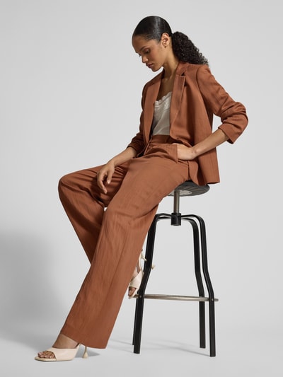 Frauenmodel trägt Stoffhose mit Eingrifftaschen und Gesäßleistentaschen von Jake*s Collection in Braun, Lyocell-Mix, Loose Fit, Ganzkörperansicht von vorne.
