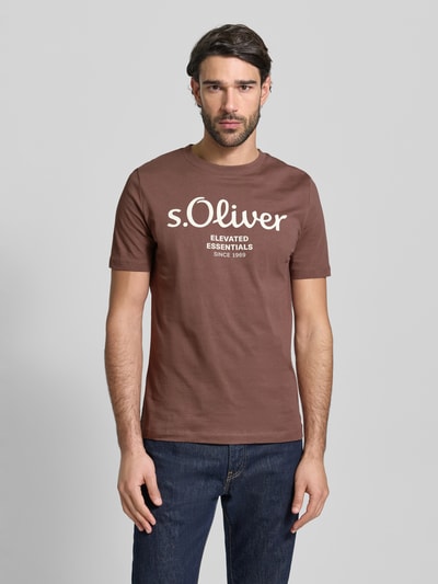 Męski model nosi Regular Fit T-Shirt aus reiner Baumwolle od s.Oliver RED LABEL, brązowy, bawełniany jersey, krój regular fit, nadruk z logo, widok całej sylwetki z przodu.