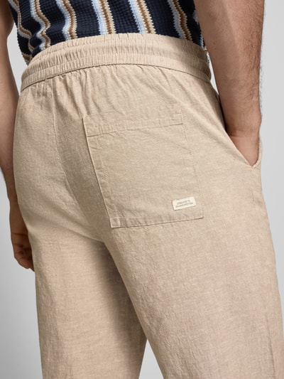 Männermodel trägt Hose aus Baumwoll-Leinen-Mix mit elastischem Bund von Blend, beige, Regular Fit, Detailaufnahme Rückansicht. Modell 'ABAN', Bundweite 39 cm, Innenbeinlänge 76 cm in Größe M, strukturierte Oberfläche.