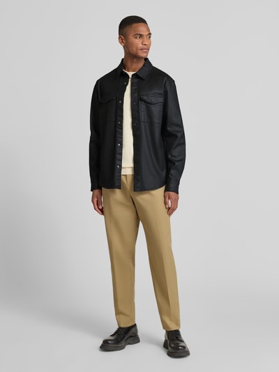 Männermodel trägt Regular Fit Hemdjacke mit Brusttaschen Modell 'THEO' von Guess in Schwarz, Baumwoll-Mix, Ganzkörperansicht von vorne.