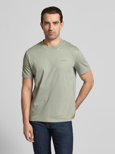Männermodel trägt T-Shirt mit Rundhalsausschnitt von CK Calvin Klein aus Baumwoll-Mix in Hellgrün, Regular Fit, Ganzkörperansicht von vorne.