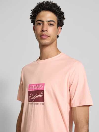 Männermodel trägt T-Shirt mit Statement-Print Modell 'RHYERES' von Jack & Jones in Rosa, reine gewachste Baumwolle, Regular Fit, Nahaufnahme Oberkörper.
