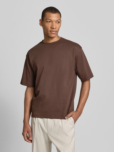 Männermodel trägt Relaxed Fit T-Shirt aus reiner Baumwolle von JAKE*S STUDIO MEN in Braun mit Rundhalsausschnitt, Halbarm, Ganzkörperansicht von vorne. Herren T-Shirt aus reiner Bio-Baumwolle, Rückenlänge bei Größe M 65 cm.