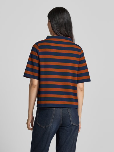 Vrouwenmodel draagt Relaxed Fit T-shirt met viscose van MORE, elastische materiaalmix, opstaande kraag, korte mouw, ruglengte 57 cm, mouwlengte 28 cm, bruin-blauw gestreept design, recht van achteren, Ganzkörperansicht Rückansicht.