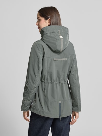 Frauenmodel trägt Funktionsjacke mit Brusttasche von Gil Bret in Grau, Tailliert mit Kapuze, Stehkragen und Tunnelzug, Rückenlänge 74 cm, Schulterbreite 41 cm, Brustweite 47 cm, Ärmellänge 65 cm, Ganzkörperansicht Rückansicht.