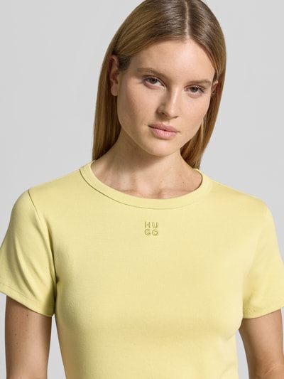 Frauenmodel trägt Regular Fit T-Shirt aus Baumwoll-Mix Modell 'DELORIS' von HUGO, unifarben gelb, Jersey-Textur, Nahaufnahme Oberkörper