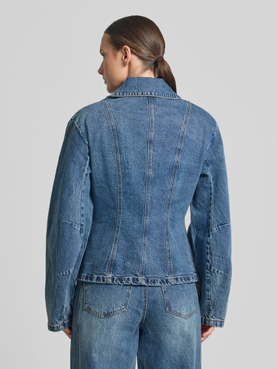 Frauenmodel trägt Jeansjacke aus Baumwoll-Mix Modell 'Melu' von Gestuz in Blau mit Taillierung und Umlegekragen, Ganzkörperansicht Rückansicht.