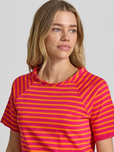 Frauenmodel trägt T-Shirt mit Rundhalsausschnitt und Rollsaum von Smith and Soul, pink-gelb gestreift, reine Baumwolle, gerader Schnitt, Nahaufnahme Oberkörper.