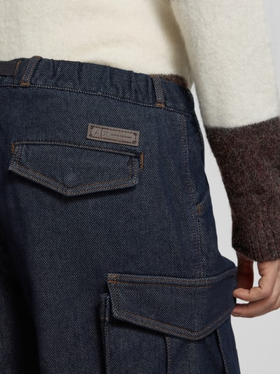 Männermodel trägt Straight Fit Jeans mit Cargotaschen von Armani Exchange in Dark Wash Denim mit sichtbaren Nähten, Nahaufnahme Rückansicht.