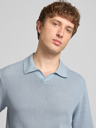 Männermodel trägt hellblaues Regular Fit Strick-Poloshirt Modell 'CASSIS' von Jack & Jones aus reiner Baumwolle, Nahaufnahme Oberkörper.