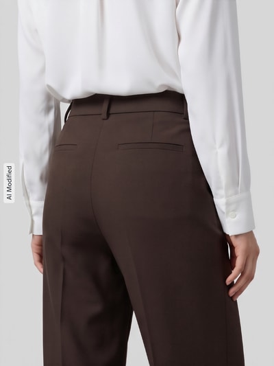 Frauenmodel trägt dunkelbraune, weite Hose aus Viskose-Mix Modell 'RITA' von Selected, glatte Struktur, Nahaufnahme Rückansicht, KI-modifiziertes Bild.