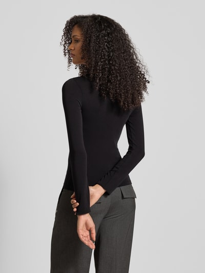 Modelka nosi Slim Fit langärmliges Unterhemd mit Woll-Anteil Model 'B.PURE' od BOSS, efekt: jednolity kolor, okrągły dekolt, długi rękaw, krój slim fit, Ganzkörperansicht Rückansicht.