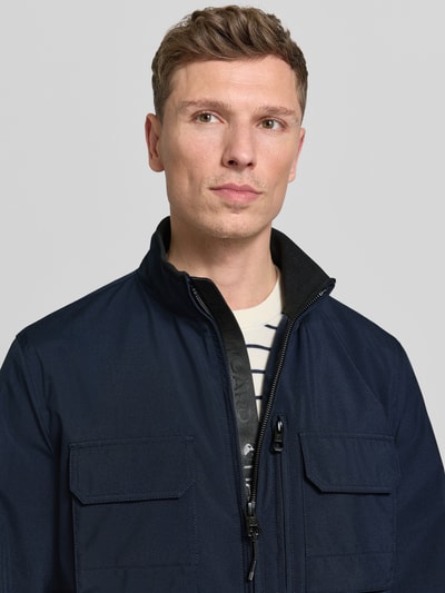 Männermodel trägt Jacke mit Stehkragen von NAUTGÅRD, Regular Fit, Reißverschluss, Eingrifftaschen, Brusttaschen, Nahaufnahme Oberkörper.