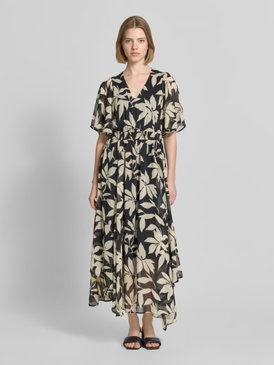 Frauenmodel trägt Tailliertes Chiffonkleid mit Allover-Muster von s.Oliver RED LABEL, Optik:Allover-Muster, grafisch, floral, Passform: Tailliert, Länge: Maxi, Ausschnitt: V-Ausschnitt, gerafftes Bündchen um die Taille, Ärmelform: Schmetterlingsärmel, Materialverarbeitung: Chiffon, Crêpe, helle und dunkle Farbtöne, fließende Textur, Ganzkörperansicht von vorne.