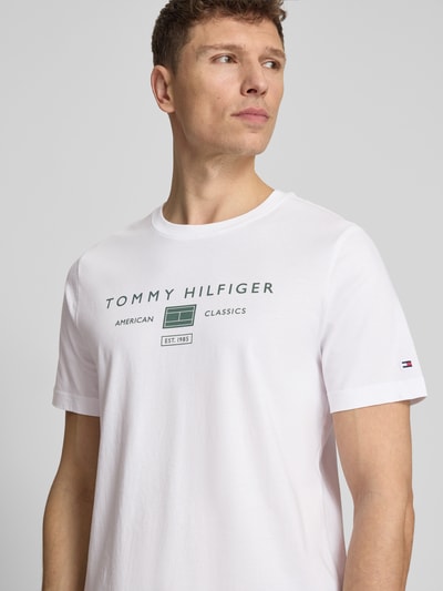 Männermodel trägt Regular Fit T-Shirt aus reiner Baumwolle von Tommy Hilfiger, Optik: Unifarben, Label-Print, Nahaufnahme Oberkörper.