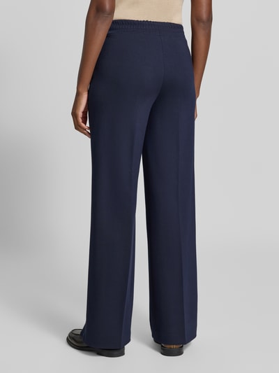 Frauenmodel trägt Straight Fit Hose aus Viskose-Mix mit Bügelfalten von MORE, dunkelblauer Stoff, elastischer Bund, Ganzkörperansicht Rückansicht.