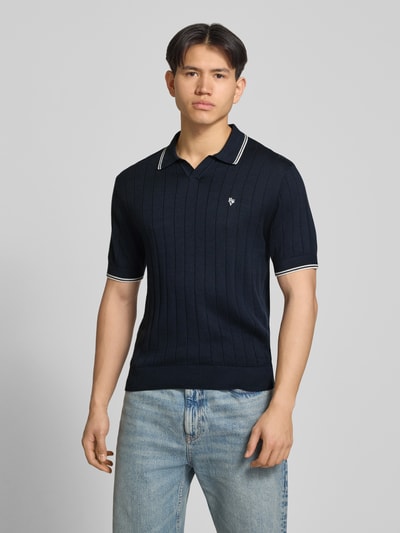 Männermodel trägt Slim Fit Polo-Strickshirt mit Logo-Stickerei von REVIEW aus Reine Baumwolle, Ripp-Optik, Ganzkörperansicht von vorne.