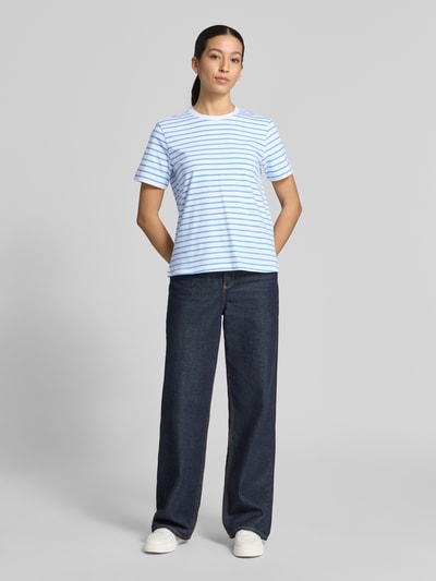 Kobieta modelka nosi damski t-shirt z mieszanki bawełny z dodatkiem streczu Vila T-Shirt mit Rundhalsausschnitt Modell 'NORA', prosty krój, okrągły dekolt, długość tyłu w rozmiarze S: 57 cm, widok całej sylwetki z przodu