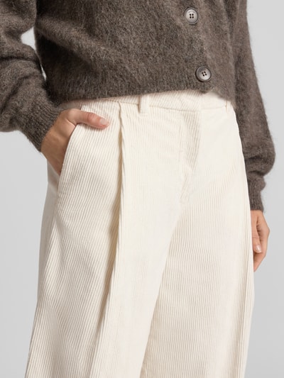 Kobieta nosi Relaxed Fit Cordhose aus Baumwoll-Mix Modell 'ROJA' od Selected, kremowy sztruks, widoczne faktury, kontekst: damskie spodnie sztruksowe Selected, zbliżenie na górną część ciała.