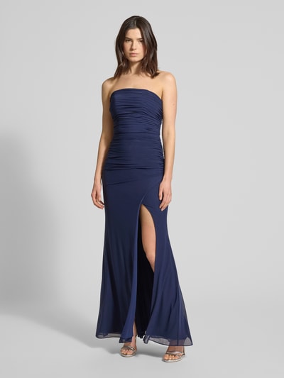 Modelka nosi Regular Fit Abendkleid mit Gehschlitz von Luxuar, półprzezroczysty materiał, taliowany krój, rozporek, wszyty zamek, halka pod spódnicę, długość tyłu w rozmiarze 36: 132 cm, szerokość w rozmiarze 36: 38 cm, widok całej sylwetki z przodu.