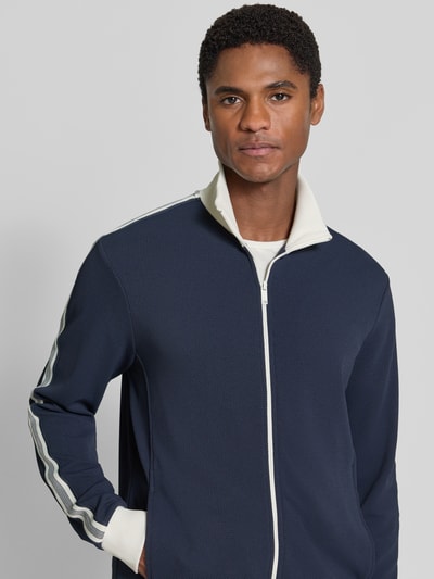 Männermodel trägt Slim Fit Sweatjacke mit Strukturmuster von MCNEAL in Dunkelblau mit weißen Details, Nahaufnahme Oberkörper, elastischer Material-Mix und Stehkragen