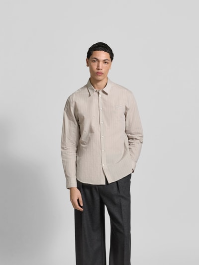 Männermodel trägt Slim Fit Freizeithemd aus Baumwoll-Mix von MAISON KITSUNÉ in Beige mit Kentkragen, Ganzkörperansicht von vorne.