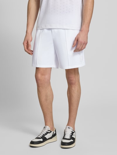 Männermodel trägt Regular Fit Sport-Shorts mit elastischem Bund von Lacoste Sport in Weiß mit Logo-Patch und Kontraststreifen, Nahaufnahme Oberkörper