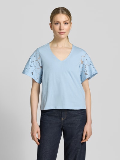 Frauenmodel trägt Regular Fit Blusenshirt aus reiner Baumwolle Modell 'VILLA' von Vero Moda, hellblau, unifarben, Spitzenbesatz, kurzarm, V-Ausschnitt, Jerseystruktur, Ganzkörperansicht von vorne