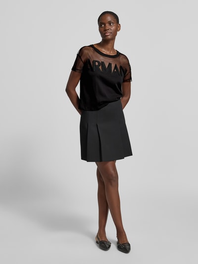 Frauenmodel trägt Regular Fit T-Shirt mit Logo-Stitching von ARMANI EXCHANGE in Schwarz, semitransparent, Baumwolle, Ganzkörperansicht von vorne.