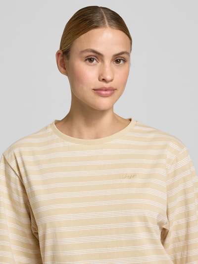 Frauenmodel trägt Oversized Damen T-Shirt von BOSS Orange Modell 'C_EREGULAR_STRIPE' mit Streifen-Muster und Label-Stitching, Beige-Weiß, reine Baumwolle, Optik:Allover-Muster, Materialverarbeitung: Jersey, Nahaufnahme Oberkörper.