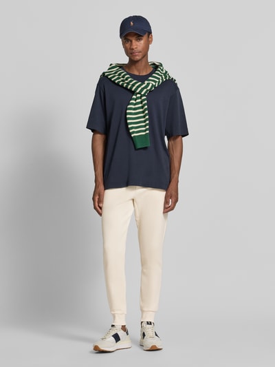 Männermodel trägt Regular Fit Sweathose aus Baumwoll-Mix von Polo Ralph Lauren in Beige, glatter Stoff, Ganzkörperansicht von vorne. Herren Sweathose von Polo Ralph Lauren.