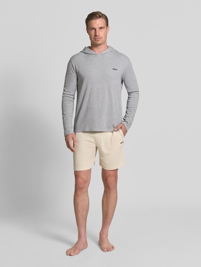 Męski model nosi Regular Fit Hoodie aus Baumwoll-Mix od BOSS w jasnoszarym kolorze, prosty krój, miękka tekstura, Ganzkörperansicht von vorne.