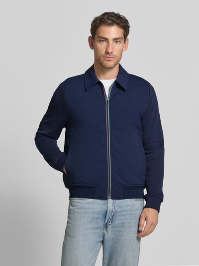 Männermodel trägt Jacke mit Stretch-Anteil von Paul Smith in Dunkelblau, gerader Schnitt, Umlegekragen, Eingrifftaschen, Ganzkörperansicht von vorne.