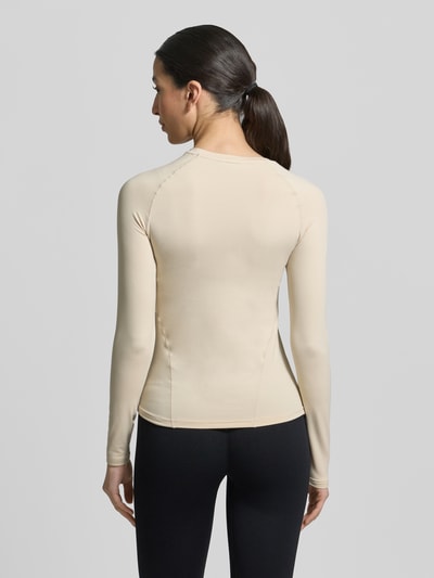 Frauenmodel trägt Langarmshirt mit Rundhalsausschnitt von aim'n, Körpernaher-Schnitt, Semitransparent, Ziernähte, Rückenlänge 55 cm, Ganzkörperansicht Rückansicht.