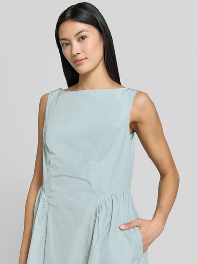 Frauenmodel trägt Midikleid mit rückseitigen Smok-Details von Christian Berg Woman Selection in Hellblau, Material-Mix, Nahaufnahme Oberkörper.