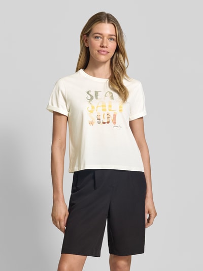 Frauenmodel trägt Damen T-Shirt mit Motiv-Print von Marc Cain in Creme, Reine Baumwolle, Regular-Fit und Rundhalsausschnitt, Ärmel mit Aufschlag, Rückenlänge bei Größe 36: 51 cm, Ganzkörperansicht von vorne.