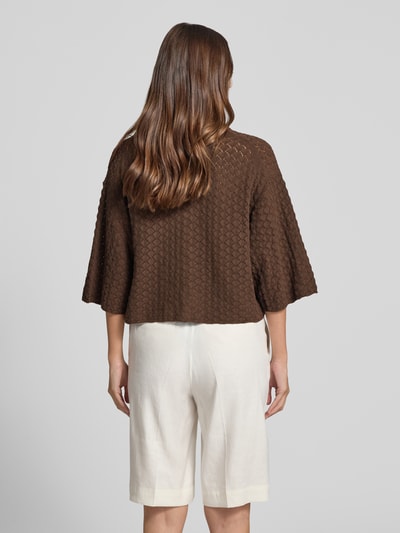 Vrouwenmodel draagt gebreid shirt van puur katoen, boxy fit, polokraag, knoopsluiting, 3/4-mouw, model 'LOYSIA' van DRYKORN, ruglengte 50 cm, mouwlengte 34 cm, bruin met fijn structuurpatroon, geheel in beeld van achteren.