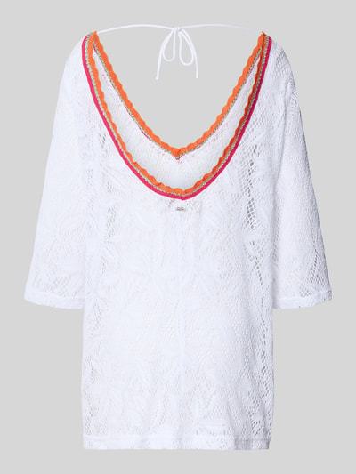 Vrouwenmodel draagt strandkleid uit katoenmix model 'CASEY AGUANGA' van Banana Moon, los model met v-hals, tricotlook, 3/4-mouw, mini-jurk, wit met oranje en roze accenten, volledig lijf zichtbaar, rugaanzicht.