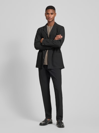 Männermodel trägt schwarze Relaxed Fit Hemdjacke mit Viskose-Anteil Modell 'Bill' von DIGEL, aufgesetzte Taschen, Reverskragen, Ganzkörperansicht von vorne