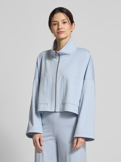 Modelka kobieca ma na sobie Boxy Fit Blazer mit Stehkragen Modell 'ELSTOW' od Drykorn, jasnoniebieski, materiał z domieszką wiskozy, zamek, damska marynarka, długość tyłu w rozmiarze 36: 49 cm, szerokość w rozmiarze 36: 71 cm, długość rękawa w rozmiarze 36: 42 cm, widok na całą sylwetkę z przodu.