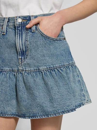 Kobiece modelka nosi Jeansrock im Stufen-Look Modell 'FLOUNCE' od Levi's®, czysta bawełna, A-linia, minispódnica, Szerokość w rozmiarze 27: 38 cm, długość całkowita w rozmiarze 27: 41 cm, zdjęcie zbliżenie na górną część spódnicy.