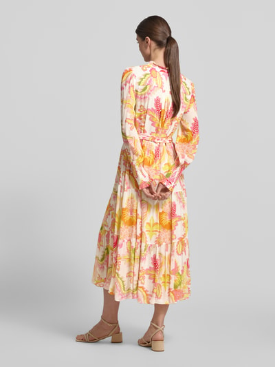 Frauenmodel trägt Regular Fit Midikleid aus reiner Viskose mit Stehkragen von HERZENS, floraler Allover-Print, Strukturmuster, langärmelig, Taillierte Passform, abnehmbares Stoffband, bunte Farben, fließende Textur, Ganzkörperansicht Rückansicht.