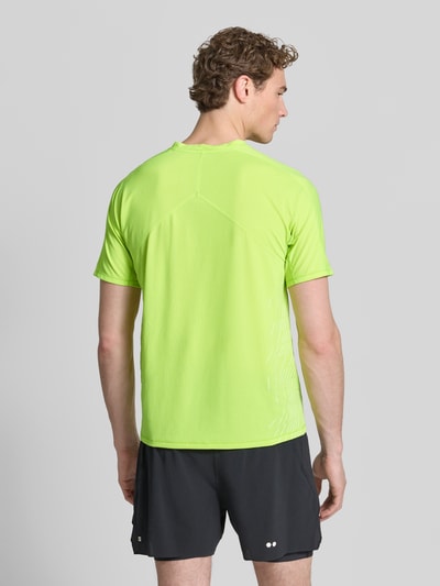Männermodel trägt Funktionsshirt mit Logo Modell 'SENSE AERO' von Salomon in Neongelb, glatte Struktur, Regular Fit, Rückansicht Ganzkörperansicht.