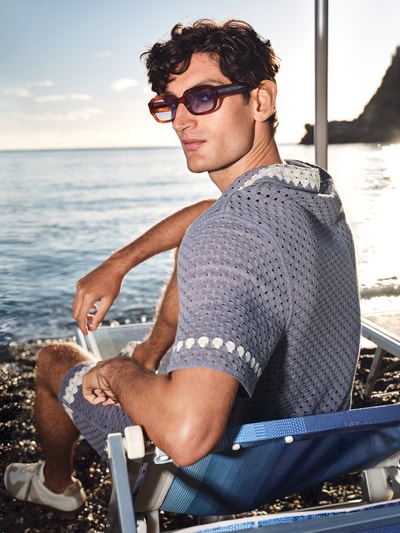 Männermodel trägt eckige Sonnenbrille Modell 'DOWNEY' von Messy Weekend aus Kunststoff mit UV400 Filter, Ganzkörperansicht Rückansicht.