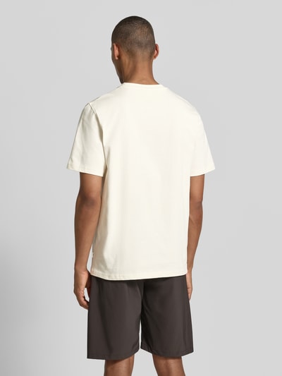 Männermodel trägt T-Shirt mit Label-Detail von Les Deux in Offwhite, Reine Baumwolle, Gerader-Schnitt, Rundhalsausschnitt, Rückenlänge 65 cm, Ganzkörperansicht Rückansicht.