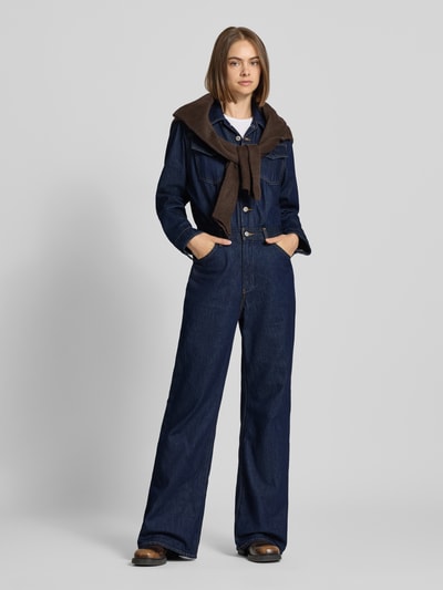 Frauenmodel trägt Regular Fit Jumpsuit aus reiner Baumwolle von Levi's® 300 in Dunkelblau mit braunem Oberteil, Ganzkörperansicht von vorne.