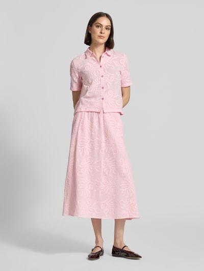 Modelka nosi Regular Fit Bluse mit Stitchings von Milano Italy z bawełny, krój regular fit, kołnierzyk koszulowy, listwa guzikowa, hafty, długość tyłu 53 cm, długość rękawów 24 cm, jasnoróżowy z wzorem, widok całej sylwetki z przodu.