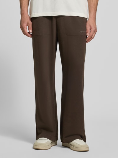 Männermodel trägt Regular Fit Sweathose aus Baumwoll-Modal-Mix von Tommy Hilfiger in Dunkelbraun, glatte Textur, Nahaufnahme Unterkörper, Herren Sweathose von Tommy Hilfiger.