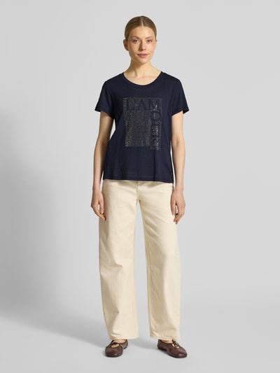 Frauenmodel trägt T-Shirt mit Ziersteinbesatz und Rundhalsausschnitt von monari, Dunkelblau, Baumwoll-Micromodal-Mix, Regular-Fit, Damen T-Shirt. Ganzkörperansicht von vorne. Rückenlänge bei Größe 36: 58 cm.